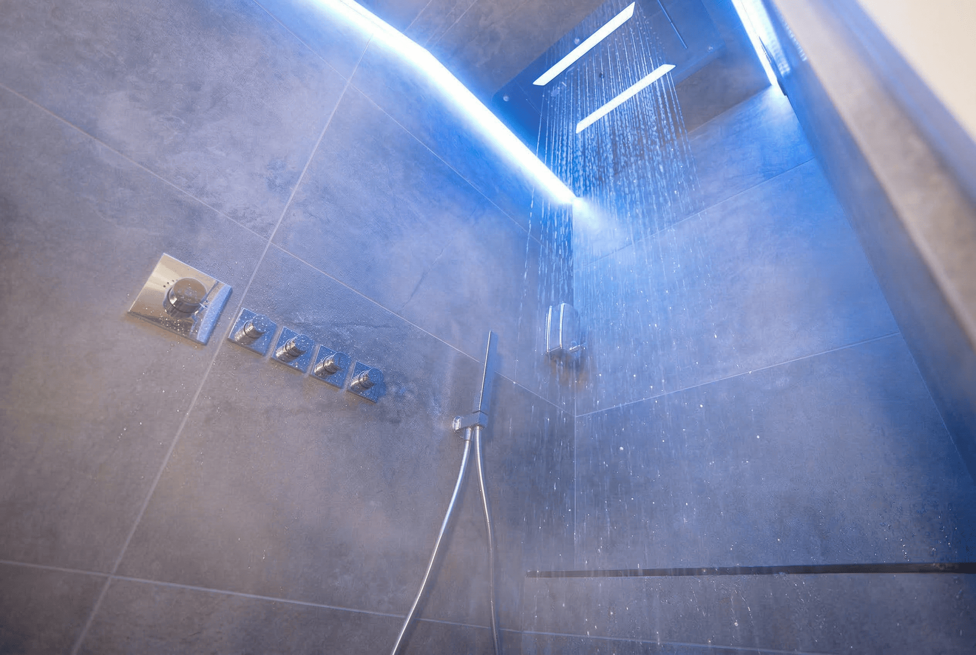 Douche sensorielle : pluie et vapeur sous la lumière bleue