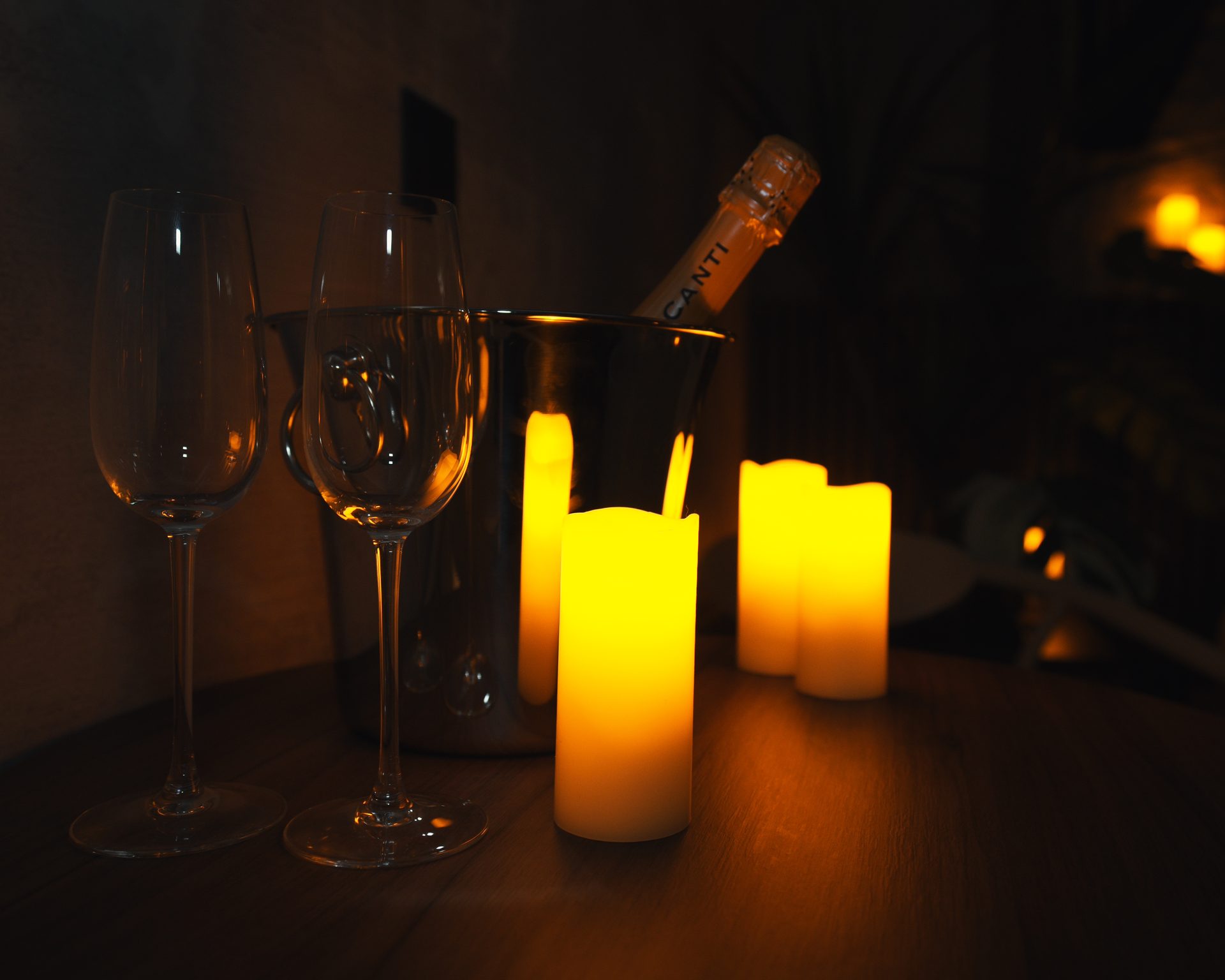 Prosecco au frais, flûtes et bougies dans la pénombre